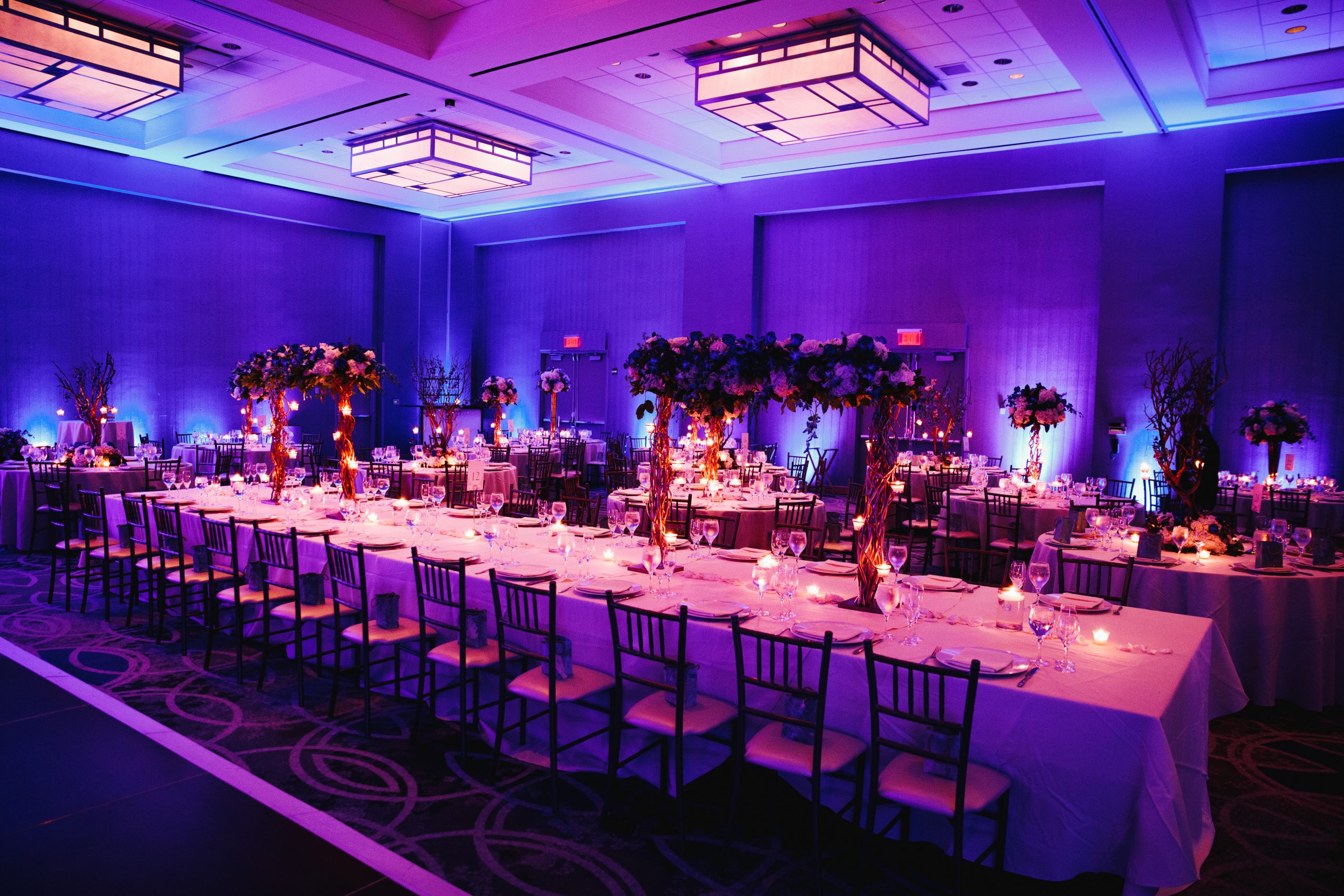 decorated banquet hall with flowers, rectangle table, chiavari c